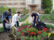 инвалиды вместе с воспитателем сажают цветы